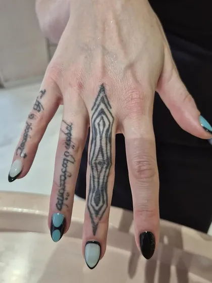 This client's hand tattoos pair perfectly with our custom geometric nail art. We love creating designs that complement your personal style.