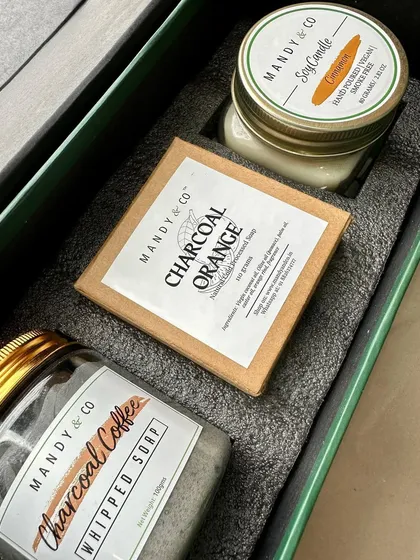 A self-care gift box for men, perfect for Raksha Bandhan, featuring charcoal coffee whipped soap, cinnamon charcoal soap, and a mint soy candle.