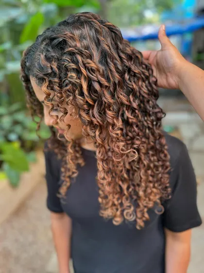 A close-up of the hand-painted highlights on these curls. The technique ensures that every curl is beautifully defined.