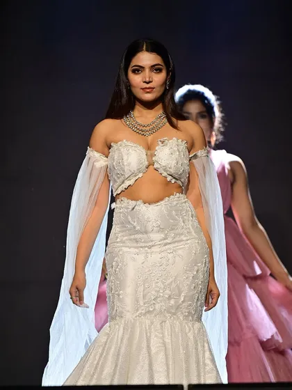 Walking the runway with confidence. The makeup is designed to be seen from afar, with highlighted cheekbones and bold eyes that command attention.