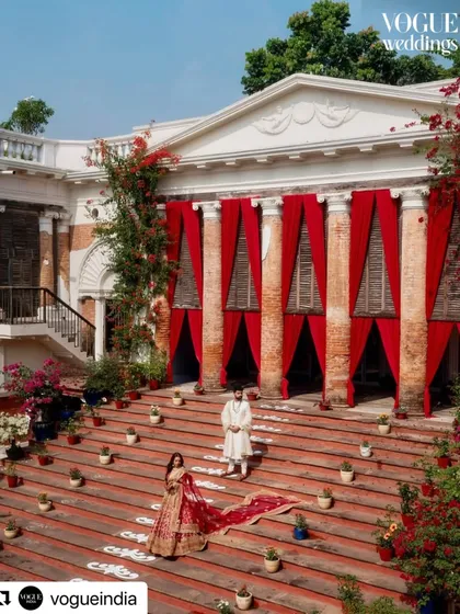 A stunning shot from Oishi and Arpit's wedding, featured in Vogue. The grand steps of the Rajbari Bawali were dramatically draped in red, creating a regal and cinematic backdrop for the couple's portraits.