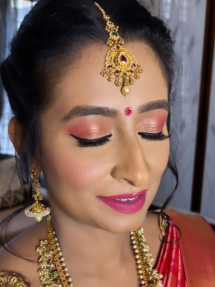The vibrant eye makeup and bold lip create a stunning look for this traditional wedding ceremony.