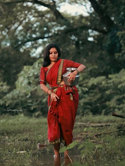 A rustic, village-themed series inspired by the movie 'Kanthara'. The model is styled in a simple red saree, captured in a natural, watery landscape to evoke a sense of raw, earthy beauty.