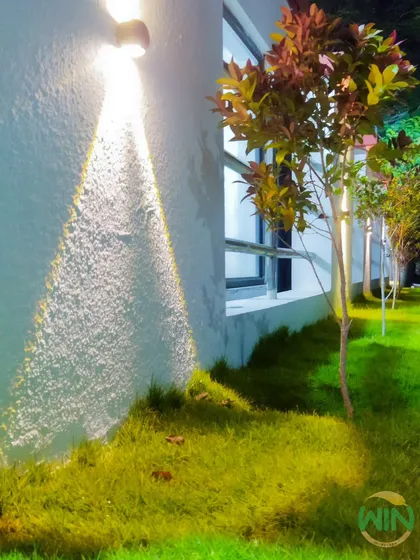 A garden's beauty shouldn't end at sunset. This image shows our strategic use of landscape lighting to highlight architectural features and trees, creating an elegant and inviting atmosphere at night.