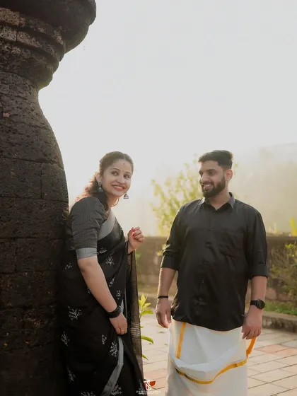 A candid moment of laughter next to the ancient stone walls of a fort. The mix of traditional attire and historic location creates a powerful image.