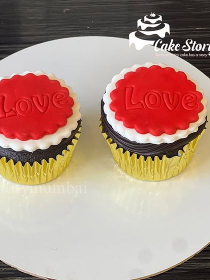 Another view of the "Love" cupcakes, showing the clean design and detailed fondant work. These are a popular choice for romantic gifting.