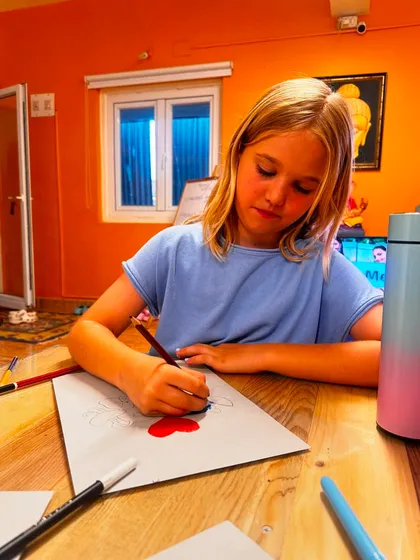 A student works diligently on her drawing, showing the focus and dedication our young artists bring to their projects.