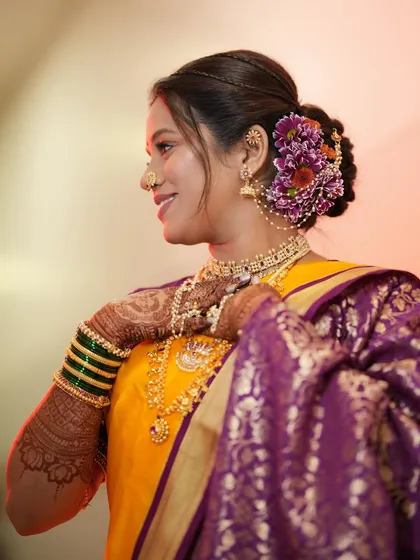 This bride's smile says it all. Her look is completed with a beautiful floral bun, traditional jewelry, and glowing makeup.