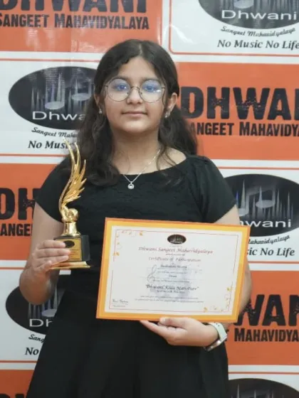 A confident student poses with her certificate and trophy for her excellent artwork.