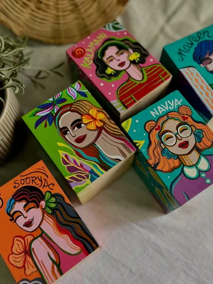 A set of personalized pen stands, each with a hand-painted portrait and the person's name.