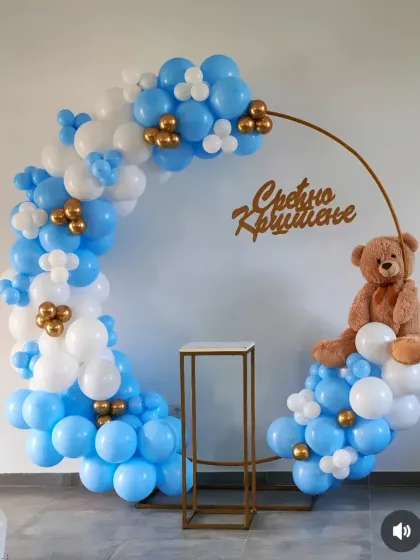 A simple blue, white, and gold balloon ring with a teddy bear, ideal for a baby's celebration.