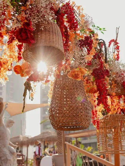 Woven baskets and vibrant flowers hanging overhead, creating a beautiful, sun-dappled effect.