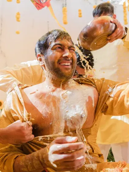 The Haldi ceremony is all about unrestrained joy, and sometimes, a little bit of madness. This shot of the groom being drenched by his friends captures the true spirit of our documentary style: real, fun, and completely unposed.