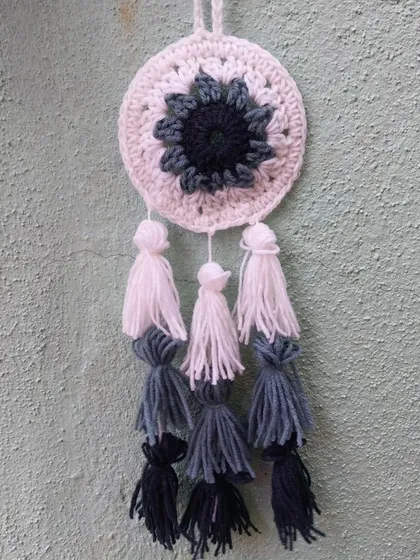 A crochet tassel dreamcatcher in shades of blue and white.