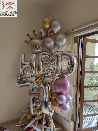 Celebrate a 17th birthday with this personalized standing bouquet. It combines 'HBD' and '17' foil balloons with a mix of silver, gold, and metallic pink balloons, topped with a small crown for a royal touch.