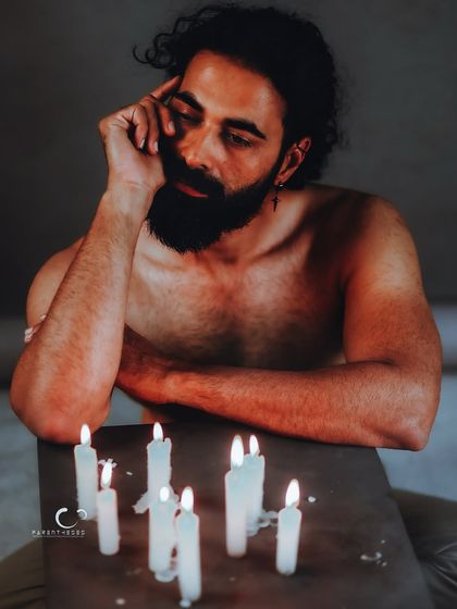 A portrait of quiet surrender, lost in thought by candlelight. The soft glow and his pensive expression create a deeply atmospheric and moving image.