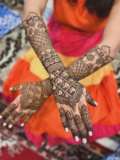 This design features a unique pattern of elephants within a grid on the back of the hands, showcasing a creative approach to traditional motifs.