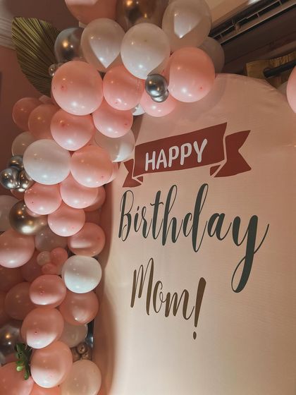 The custom-printed backdrop with the message 'Happy Birthday Mom!' adds a personal and heartfelt touch to the celebration.