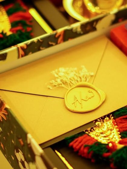 A close-up of the inside of the wedding return hamper, showing the wax-sealed envelope and the framed Nettipattom.