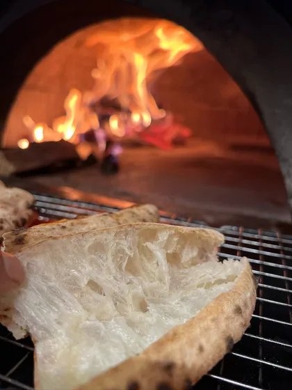 This is where the flavour is born. Our Neapolitan crust, with its soft, airy pockets, getting that perfect fire-kissed char from the wood oven. It's a difference you can taste.