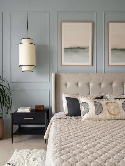 A close-up of the master bedroom bed, showing the detail of the button-tufted headboard and the elegant black metal nightstand we crafted.