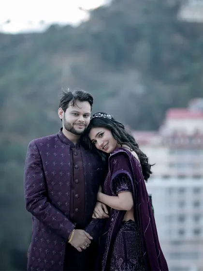 A closer portrait of the couple, where her smile lights up the frame as she leans into him. The soft focus on the background architecture emphasizes their joyful connection, making it a perfect shot for capturing the happiness of a pre-wedding getaway.