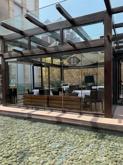 Our New Delhi restaurant is a sanctuary of light and silence. The glass-enclosed dining space is surrounded by a tranquil water feature, creating a serene backdrop for a memorable meal.