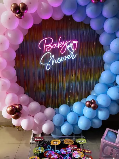 A close-up of the baby shower props placed in front of the balloon ring backdrop.