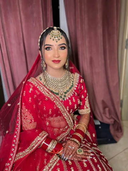A perfect shot of my bride Gurusha in her stunning red lehenga. The makeup is glamorous yet elegant, with a focus on her beautiful eyes and radiant skin.