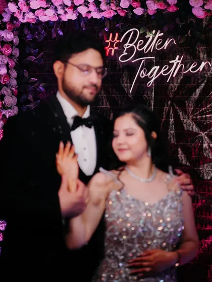 A candid shot of the couple in front of a 'Better Together' neon sign, perfectly capturing the theme of their celebration.
