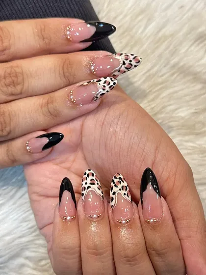 I love mixing patterns to create a unique look. This set combines a fierce leopard print with bold, black V-shaped French tips and delicate gold stud accents for a chic and edgy style.