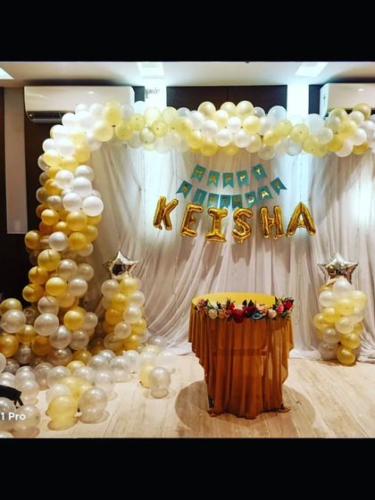 The same elegant birthday setup in natural light, showcasing the beautiful white and gold color scheme.