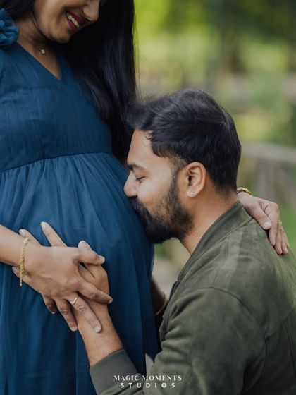 A sweet moment of listening for the baby's heartbeat. This pose is a favorite for dad-to-be, filled with anticipation and love, taken on a rustic wooden bridge.