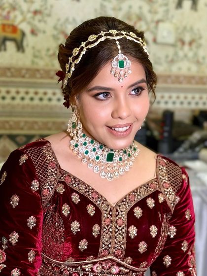A close-up of the regal red bridal look, showing the soft sculpt, defined eyes, and berry-toned lip.