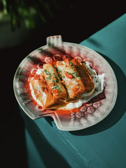 Inspired by a warm hug, this slow-braised lamb is enveloped in crisp filo, infused with aromatic spices, and paired with a zesty mint yogurt.