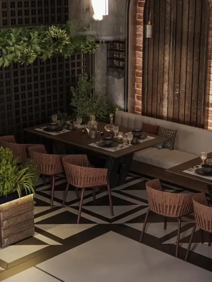 This intimate dining corner uses rustic brick, dark wood, and hanging plants to create a cozy, tavern-like atmosphere. The patterned floor adds a touch of modern geometry to the rustic design.