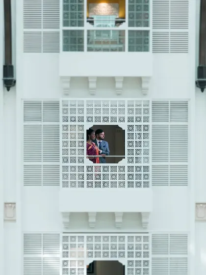 A quiet moment for the couple, framed against the grand architecture. We love finding these unique, cinematic shots that feel like a scene from your own personal movie.