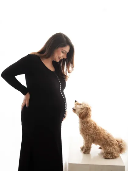 A simple and elegant maternity portrait of an expecting mother sharing a sweet moment with her poodle. We love including furry friends in our sessions.