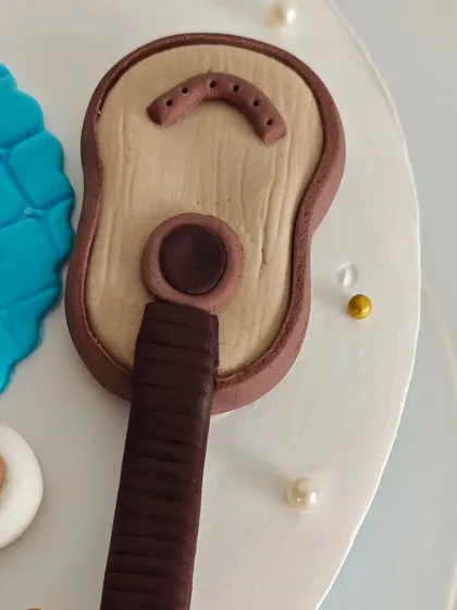 A detailed shot of the fondant guitar, showing the wood grain texture and strings. Every little detail matters when telling a story.