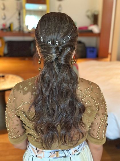 A beautiful textured low ponytail with a modern twist. The personalized "SHREY" hairpins add a unique touch, a creative idea I share with my students.