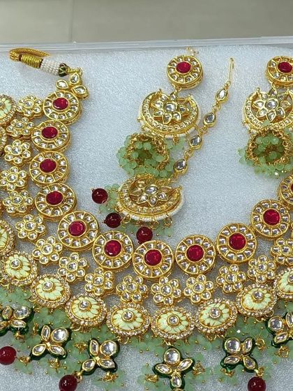 A lovely pastel-themed kundan set with light green meenakari and ruby-red stones. This style is very popular for daytime weddings and pre-wedding photoshoots.