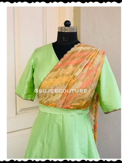 Here is a closer look at the bodice of the green silk gown. You can see the clean V-neckline and how the printed dupatta is seamlessly integrated into the design. The delicate lacework on the sleeve edges adds a simple, elegant touch to the final piece.