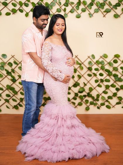 Simple, elegant, and modern. This portrait features a pink fishcut gown against a clean, leafy backdrop, highlighting the beauty of the baby bump with a touch of contemporary style.