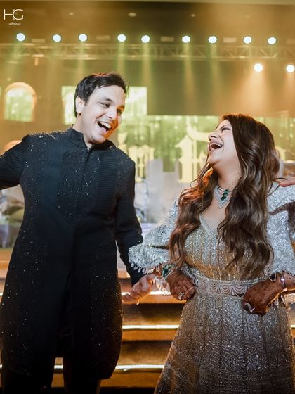The joy of the occasion is what matters most. Piyush Bansal and his partner, sharing a laugh during their celebration, with his custom sherwani adding to the moment's elegance.