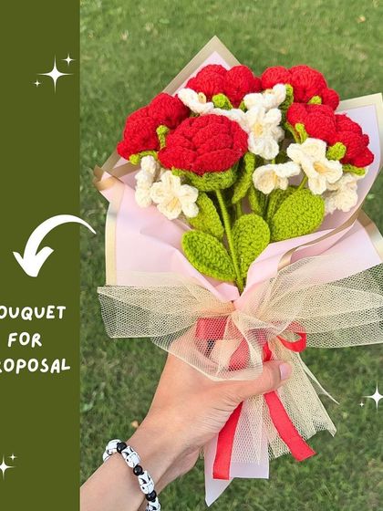 The perfect bouquet for a proposal. This arrangement of red carnations and white forget-me-nots is wrapped in pink paper with a delicate net overlay.