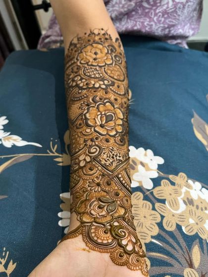 A heavy, intricate design on the forearm, featuring bold flowers and geometric fills.