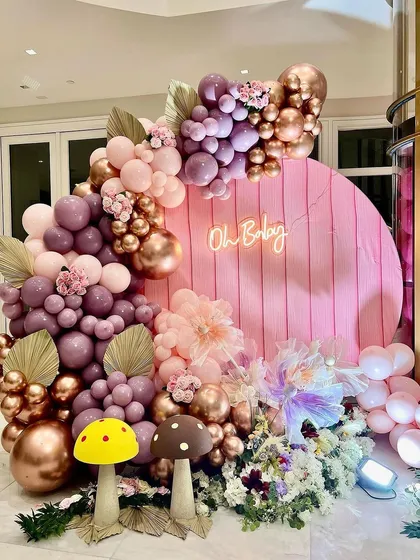 This enchanted garden theme is all about the magical details. I combined shades of mauve, pink, and rose gold with a custom "Oh Baby" neon sign, whimsical mushroom props, and a base of artificial flowers to create a fairytale photo corner.