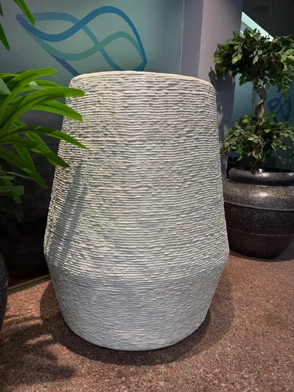 This tall, textured white planter is perfect for housing a large indoor or outdoor plant, adding height and elegance to any corner.
