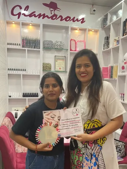 This student from Lucknow holds her certificate and a wheel of her practice designs, showcasing the skills she learned.