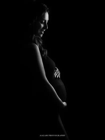 A minimalist portrait dedicated to all mothers. The soft light on her smiling face and baby bump is a beautiful tribute to motherhood.